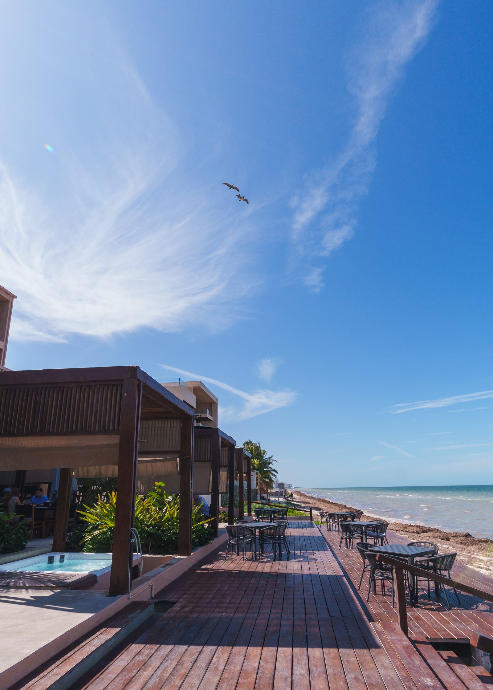 Restaurante sobre deck de madera frente al mar en Playaviva